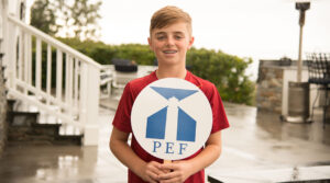 boy holding PEF sign